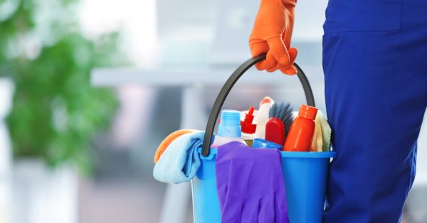 holding cleaning products and tools on bucket, close up